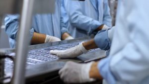 Workers in a pharmaceutical facility packaging tablets, tied to Coretime for pharma consultant time and project management.