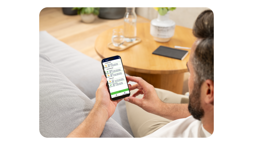 Man approving leave requests using the coretime mobile app on his phone while relaxing at home.